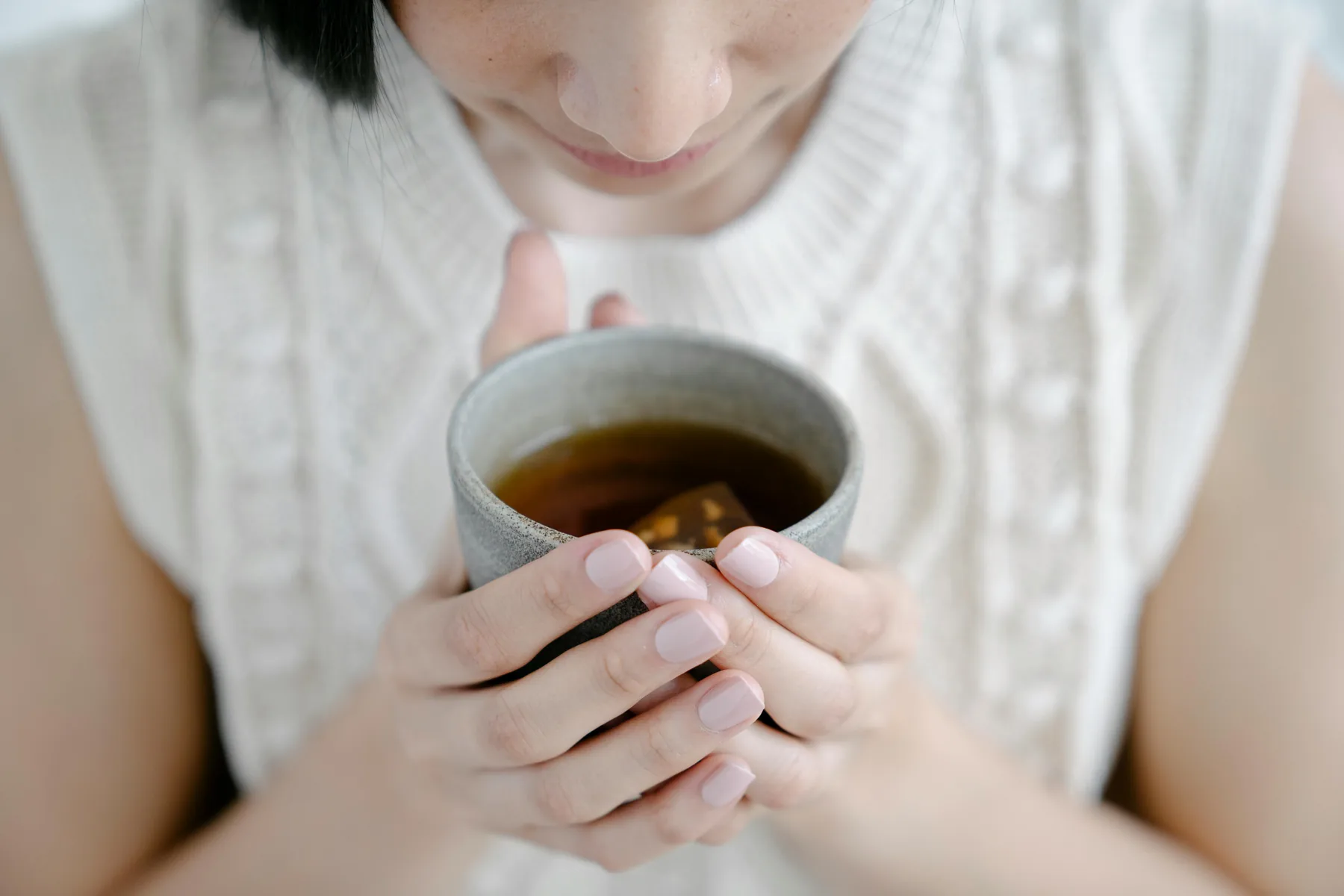 Femme tenant une infusion chaude au gingembre