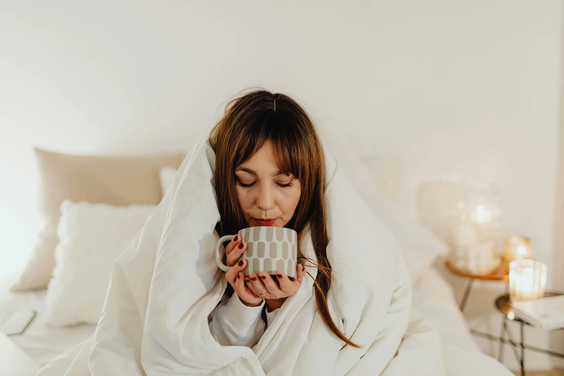 Une personne se réchauffe les mains autour d’une tasse chaude
